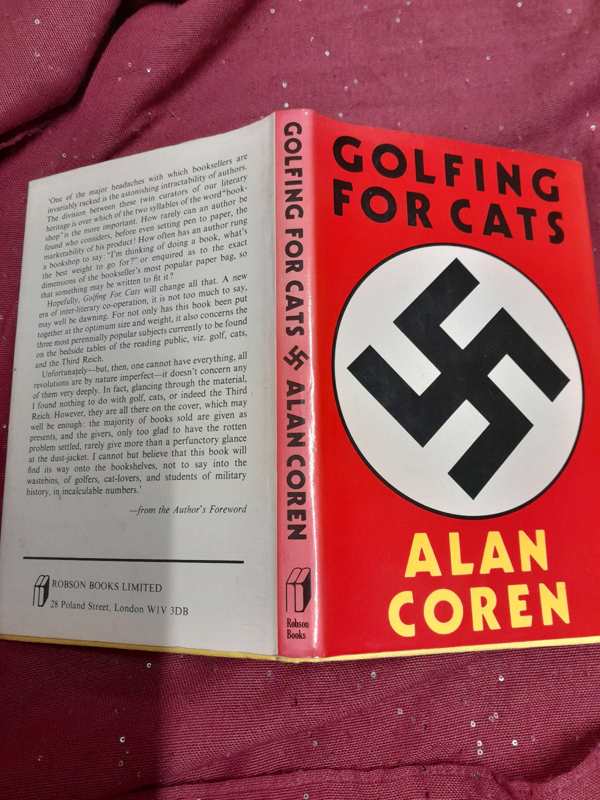 Book titled 'Golfing for Cats' by Alan Coren with a red cover featuring a black swastika symbol on a red background.