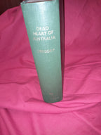 Green book titled 'Dead of Heart of Australia' on a pink fabric background