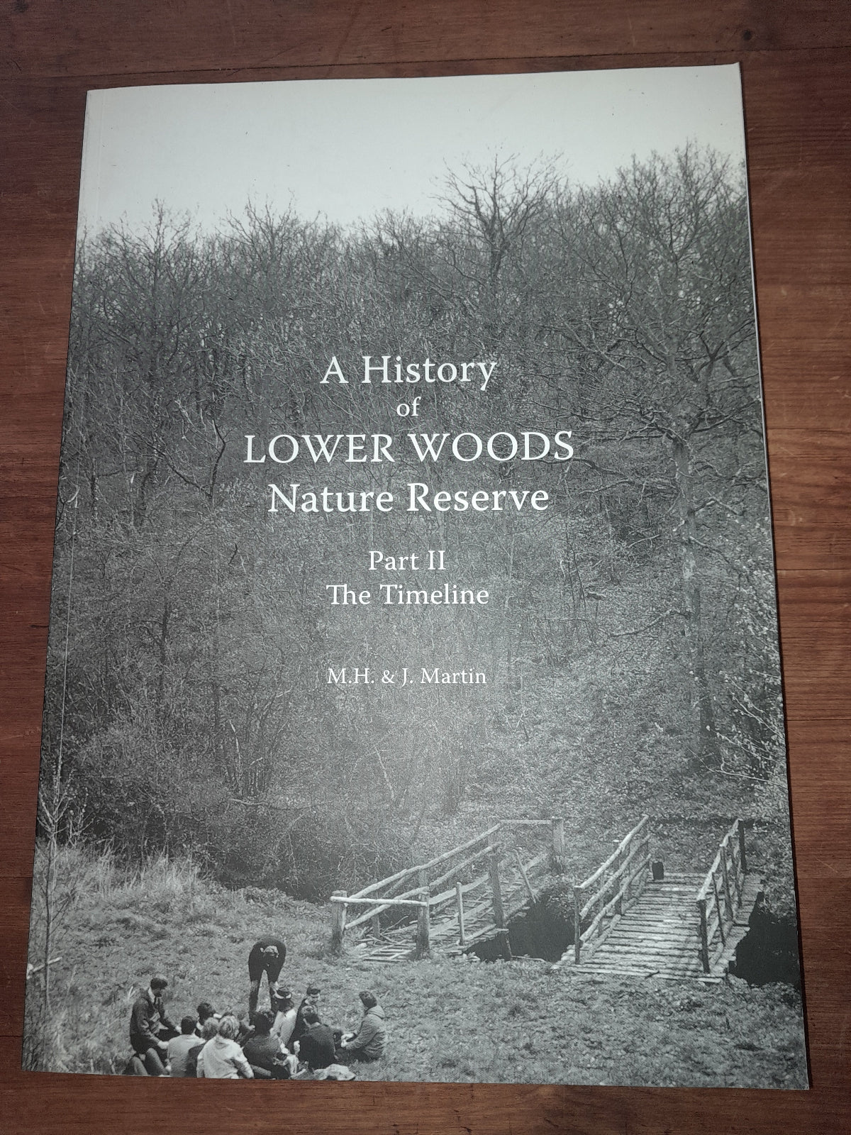Book titled 'A History of Lower Woods Nature Reserve Part II' on a wooden surface