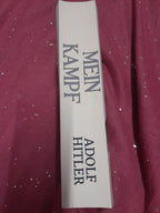 Label for 'Mein Kampf' by Adolf Hitler on a maroon fabric background