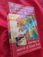 Two books on a red background, one titled 'Somewhere Down the Crazy River' and the other 'Journeys in Search of Giant Fish'.